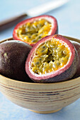 Close-up of Passion Fruit Cut in Half in Bowl on Blue Background,Studio Shot