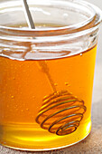 Nahaufnahme eines Honigglases mit Honiglöffel