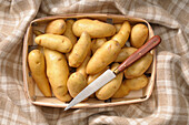Draufsicht auf Kartoffeln im Korb mit Messer