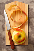 Overhead View of Apple with Skin Peeled on Cutting Board with Knife,Studio Shot
