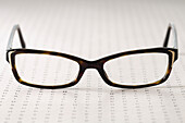 Nahaufnahme einer Brille auf einer Augenuntersuchungstafel, Studioaufnahme