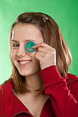 Teenage Girl Holding Condom to Eye
