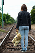 Mädchen im Teenageralter, das auf Eisenbahnschienen geht