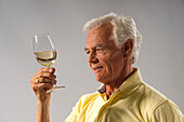 Mann betrachtet Wein im Glas