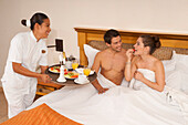 Paar wird Frühstück im Bett im Hotel serviert