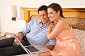Paar mit Laptop im Hotelzimmer, Reef Playacar Resort and Spa, Playa del Carmen, Mexiko