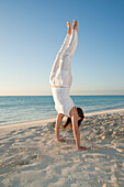 Frau macht Handstand am Strand,Reef Playacar Resort and Spa,Playa del Carmen,Mexiko