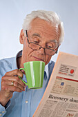 Man Drinking Coffee and Reading Newspaper