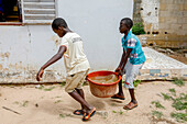Boys fetching water in Thiaoune,Senegal,West Africa,Africa