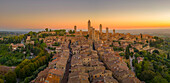 Elevated view of rooftops and town at sunrise,San Gimignano,Tuscany,Italy,Europe