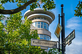 Blick auf Schild und Gebäude am baumgesäumten Kurfurstendamm in Berlin,Deutschland,Europa