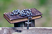 Bibel und katholische Rosenkranzperlen auf Holz,Les Contamines,Haute-Savoie,Frankreich,Europa