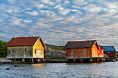 Traditionelle alte Rorbu-Hütten mit Blick auf das Meer bei Sonnenuntergang, Norwegen, Skandinavien, Europa