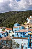 Person doing slide (zip line) in blue painted Smurf village of Juzcar,Pueblos Blancos region,Andalusia,Spain,Europe