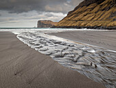 Channel running into the ocean looking towards the cliffs and sea stacks of Risin and Kellingin,Tjornuvik,Faroe Islands,Denmark,Europe