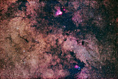 This is a rich region in the Milky Way in northern Sagittarius. with four Messier objects: The Small Sagittarius Starcloud,aka Messier 24,is at right of centre,flanked by: the pink Messier 17,the Swan or Omega Nebula,above; and the star cluster Messier 25 at lower left. Above M25 at upper left is the star cluster NGC 6645. Below M17 is the small star cluster Messier 18. The small but rich star cluster embedded in the Starcloud is NGC 6603. The nebulosity at bottom is IC 1283,a red emission nebula; and NGC 6589/90 and NGC 6595,both blue reflection nebulas. The dark nebula on the west (right) si