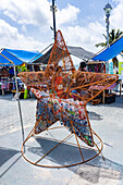 Ein Metalleimer in Form eines Seesterns für das Recycling von Plastikwasserflaschen auf dem Markt in San Pedro, Ambergris Caye, Belize.