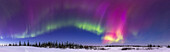 Ein 150°-Panorama des Polarlichts in der tiefen Dämmerung in einer Kp6-Nacht am 26. Februar 2023 von der Beobachtungsplattform im zweiten Stock des Churchill Northern Studies Centre in Churchill, Manitoba, auf 58° N.