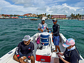 Dive guides & female tourist on a snorkeling trip to the Hol Chan Marine Reserve on the Belize Barrier Reef,Ambergris Caye,Belize.