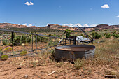 Ein alter Bewässerungstank und eine eingestürzte Windpumpe oder Windmühle auf einer ehemaligen Rinderfarm im Südosten von Utah.