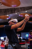 Junger Mann spielt mit Meta Quest 2 All-in-One VR-Headset während ZGamer, einem Festival für Videospiele, digitale Unterhaltung, Brettspiele und YouTuber während der Fiestas del Pilar in Zaragoza, Aragonien, Spanien
