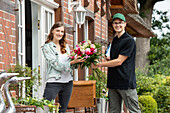 Delivery service - supplier hands over bouquet of flowers