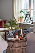 Decorated living area with wooden barrel, candles and fir branch in a glass