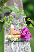 Natural lip balms in bamboo covers decorated with flowers on wooden railings