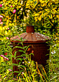 Garden incinerator amongst weeds