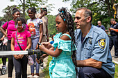 Firefighter demonstrating fire hose to children