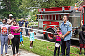 Firefighter demonstrating fire hose to children