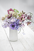Spring flower arrangement with blue anemone, hellebore, hyacinths and snakehead mother-of-pearl butterflies