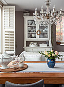 Country-style dining room with wooden buffet and crystal chandelier