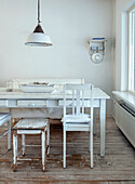 Dining area with white wooden table and chairs and rustic pendant light