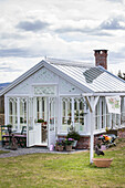 White greenhouse with decorative windows in the country garden