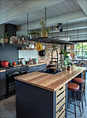 Modern kitchen with wooden beamed ceiling and wooden island