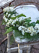 Flower arrangement of white roses and daisies on a rustic table in the garden