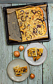 Onion focaccia on tray and pieces on plates