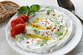 Labneh garnished with roasted tomatoes, olive oil and Aleppo pepper