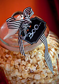 Popcorn in a glass container with Halloween decoration and "Boo" pendant