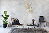 Seating area with rattan furniture, African sculpture and seagrass wall decoration