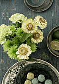 Flower arrangement of white zinnias and carnations on a rustic wooden table