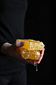 Woman holding dripping honeycomb