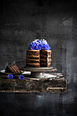 Layered chocolate caramel cake with cornflowers