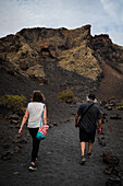 Volcan del Cuervo (Krähenvulkan), ein Krater, der über einen Rundweg in einer kargen, felsigen Landschaft erkundet wird