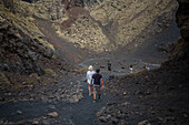 Volcan del Cuervo (Krähenvulkan), ein Krater, der über einen Rundweg in einer kargen, felsigen Landschaft erkundet wird