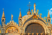 Basilica San Marco reflected in acqua alta in Piazza San Marco at twilight during sunset, Venice, Italy with motion blur on the crowds of tourists