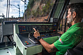 Train driver of the Cremallera Rack railway train climbing up Montserrat mountain, Monistrol de Montserrat, Barcelona, Spain.