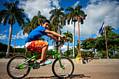 Boy riding in a bicycle in the Central Park of Nahuizalco Sonsonate El Salvador Central America. Ruta De Las Flores, Department Of Sonsonate.