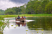 Amazon river boat trip expedition by boat along the Amazon River near Iquitos, Loreto, Peru. Navigating next to Timicuro village